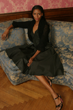 Sexy pretty woman with long black hair wearing CharmaineLouise Intimates CLIntimates Lena black cashmere sweaterlette cardigan vee neck silk taffeta evening dress heels sitting on sofa