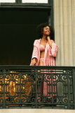 Sexy pretty woman wearing CharmaineLouise Intimates CLIntimates Diana pink cashmere crochet kimono robe crochet bra string bikini standing on balcony